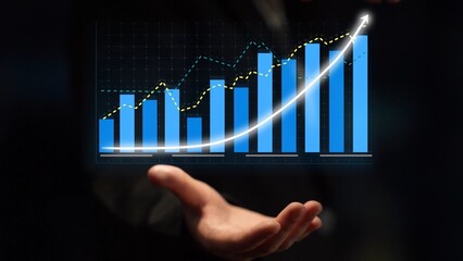 Businessman showcases a growth chart with blue bars and an upward trend, symbolizing financial...