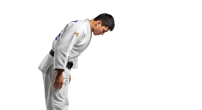 A martial artist in traditional uniform bows with respect embodying discipline and honor in a striking isolated portrait