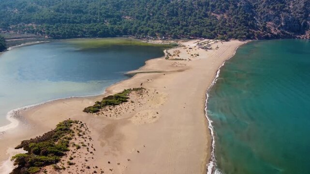 aerial footage showcasing the unique landscape of Iztuzu Beach in Dalyan, Muğla, Turkey. This pristine sandy spit acts as a natural barrier between the Mediterranean Sea and the freshwater Dalyan Rive