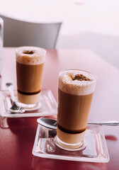 Two layered coffees served at an outdoor terrace