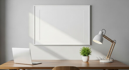 A Clean Desk with a Laptop and an Empty Poster Frame for Your Design.