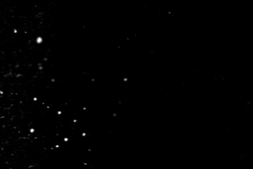 Light snowfall snow against black background. Works well as an overlay. Fine small snows. White snowflakes on black background, Blurred abstract defocused effect. Use with screen blending layer mode