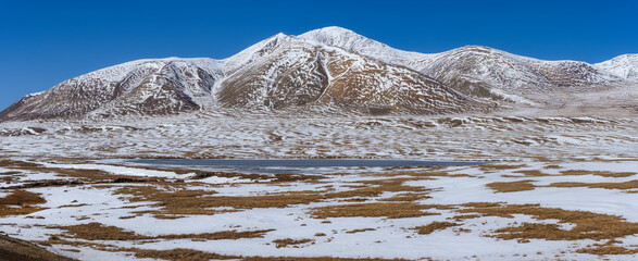 Panorama of a snow-capped mountain against a blue sky