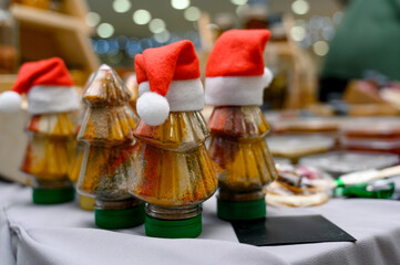 A close-up of spice jars shaped like Christmas trees with Christmas hats