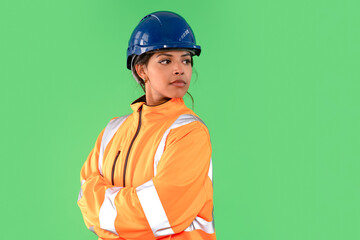 Woman construction worker wearing helmet and safety jacket on a Green background