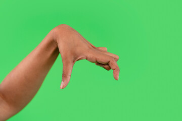 A woman's hand is positioned in a claw-like shape, with her fingers pointed downwards against a green screen background