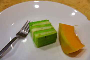 Delicious fruit cake topped with fresh kiwi slices served on a plate. The colorful dessert looks sweet and refreshing, perfect for themes of homemade baking, desserts, 