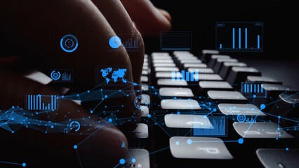 This image captures hands typing on a keyboard with digital graphs floating above, representing modern technology and data analysis in a business environment. Xenic