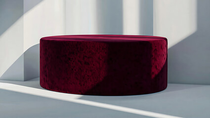 Red velvet ottoman on white background with sunlight