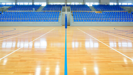 Empty indoor sports court with blue stadium seats