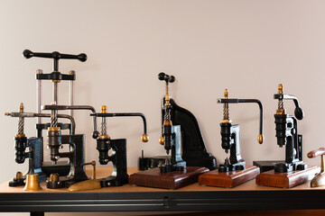 Leather rolls and classic vintage presses fill the craftsman workshop shelves. Retro leathercraft presses and shelves of cowhide hides create a true artisan studio.