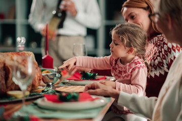 Little girl enjoying christmas dinner with family