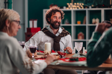 Smiling man enjoying christmas dinner with family