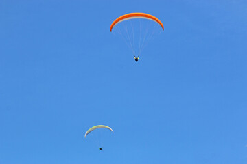 Paragliders flying in a blue sky	