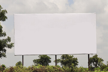 Billboard on rural area of India, outdoor advertising, mockup billing board in front of green tree and Blank white background for branding design large hoarding india Outdoor advertising construction.