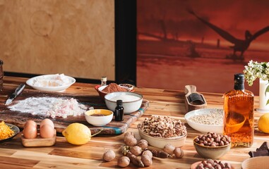 A collection of ingredients for making Cozonac, the traditional Easter bread. Eggs, flour, sugar, nuts, and flavorings are neatly arranged on a wooden table