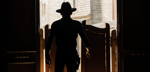 Silhouette of a cowboy at an open door