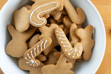 decorated and undecorated gingerbread cookies in white bowl, top view