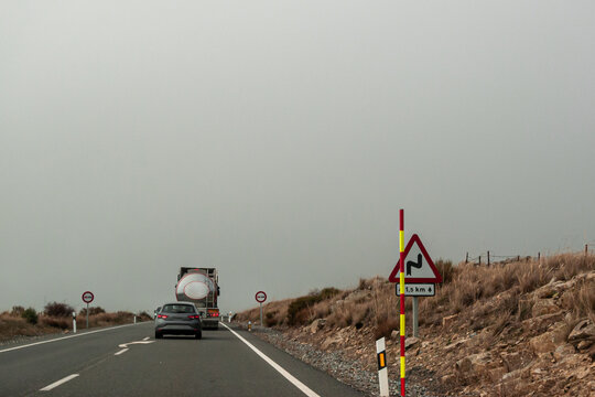 A car behind a truck will have to wait behind it, because it encounters a vertical no overtaking sign. On the asphalt there is an arrow indicating that you must leave the oncoming lane. 