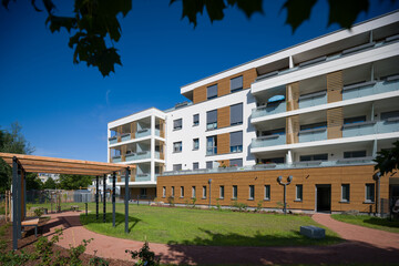 Modern apartment building with a green courtyard and wooden pergola