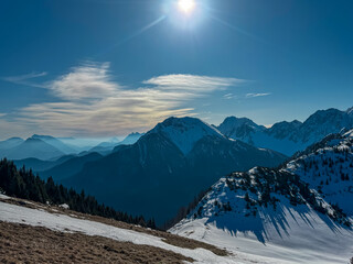 Majestic mountain peaks cast long shadows over snowy ridges as the sun glows above B&auml;rentaler Kotschna, revealing Hochstuhl, Kosiak, and Hochobir in the Karawanks, Carinthia, Austria, near Slovenia.