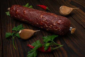 Cured Sausage with Garlic, Parsley, and Red Chili Peppers on Wooden Tabletop