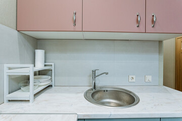 The modern kitchen sink area features a minimalist design that combines both aesthetic appeal and practical storage solutions, perfect for a clean and organized urban lifestyle in your home