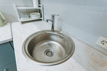 This modern stainless steel sink enhances any bright kitchens ambiance, combining elegance and functionality, making it essential for home renovations and workspace design projects