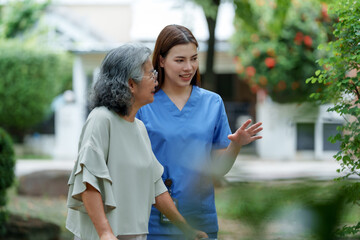 Obraz premium Caregiver provides assistance and support to senior, fostering warm connection in serene outdoor setting. This moment highlights importance of care and companionship
