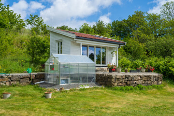 Small white garden house with greenhouse front.