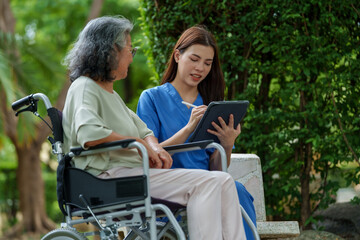 Caregiver provides assistance and support to senior in wheelchair, ensuring they receive necessary care and attention in serene outdoor setting