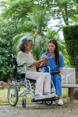 Caregiver provides assistance and support to senior in wheelchair, showcasing compassion and dedication in serene outdoor setting. scene emphasizes importance of care