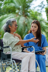 Caregiver provides assistance and support to senior in need of care while discussing important matters in serene outdoor setting. bond between them reflects compassion and understanding