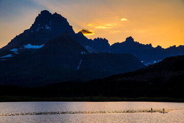 Silhouetted Paddleboarders at Sunset on Swiftcurrent Lake, Many Glacier, Glacier National Park, Montana