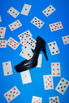Black heel surrounded by scattered playing cards