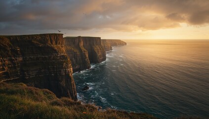 Dramatic cliffs and ocean coast with golden sunlight breaking through cloudy sky
