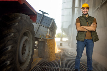 Truck unloading corn at collection point with worker