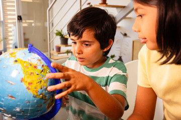 Curious children exploring the world with a globe