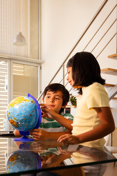Children exploring the globe at home