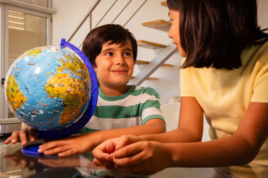 Curious children exploring world with globe
