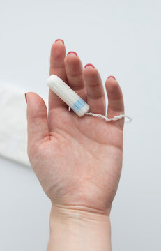 Hand holding tampon representing menstruation