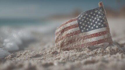 Sand-covered American flag on a beach captures summer vibes and patriotism near the ocean at sunrise - Low Contrast