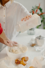 Preparing christmas treats by sifting flour into a bowl