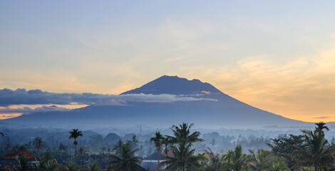 Mountain is visible in the distance with a cloudy sky in the background