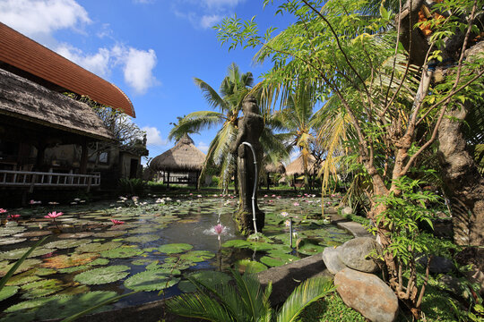 Pond with a statue of a woman and a fountain - Powered by Adobe