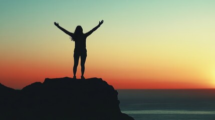 A silhouette of a person standing on a cliff, arms raised in triumph 