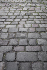 Old cobblestone sidewalk, pavement as background, perspective view. Stone Pavement or Granite Cobblestone Road Top View. Mosaic Brick Cobblestone Floor with Tiles and Small Stones
