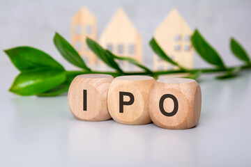 Wooden blocks with IPO letters on desk with leaves and house figures