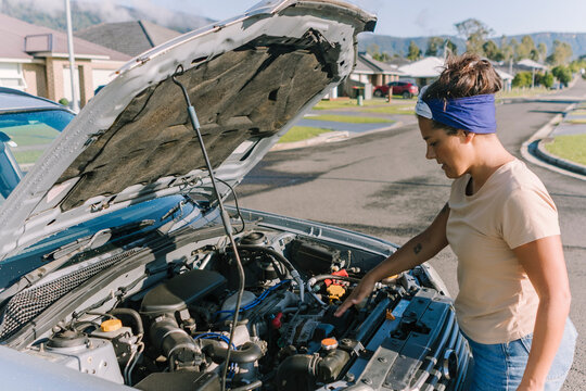 Woman with broken down car in Australian suburb