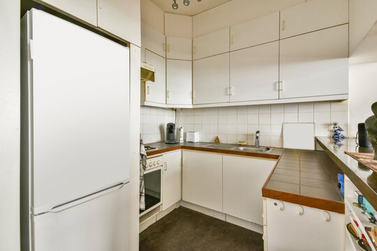Compact modern kitchen with sleek white cabinets